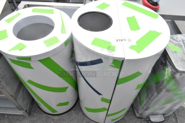 Three white cylindrical trash can shells with green tape accents, showing slight wear. Auction label "2181" indicates 3X bid.