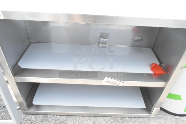 Brand new Regency 600WCO1536 36" stainless steel open wall cabinet. Minor scratches and dents visible. Unused condition.