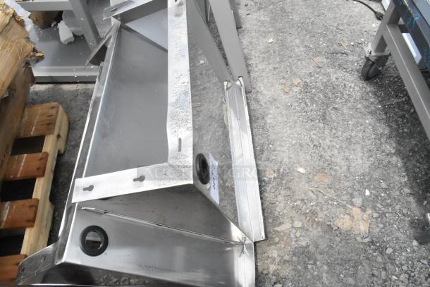 Brand new stainless steel wall mount shelf, scratch and dent condition, visible mounting brackets and protective coating.