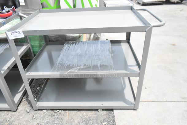 Gray metal 3-tier cart, scratch and dent, brand new, handle on side, wrapped shelf, auction tag "225/M QT 2".