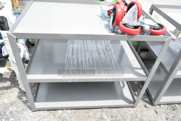 Gray metal 3-tier carts, brand new with minor scratches. Includes red caster wheels. Durable and functional. Auction offers two items.