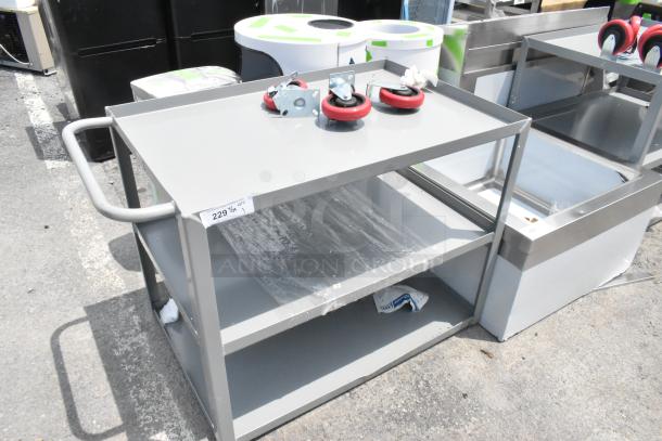 Brand new gray metal 3-tier cart with commercial casters; slight scratches and dents. Includes label with '229/1' marking.