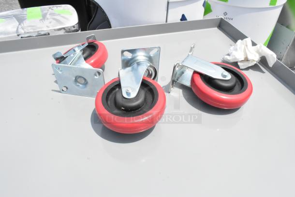 Gray metal 3-tier cart with red commercial casters, brand new with minor scratches.