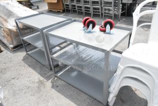 Brand new gray metal 3-tier carts with minor scratches and dents; includes red casters; auction for two.