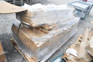Pallet with 6 new scratch and dent items, including boxed stainless steel tables, wrapped in plastic and secured with straps.