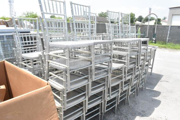50 light gray Chiavari stackable banquet chairs, outdoor view, showing durability and space-saving design.