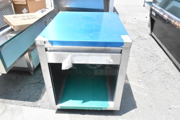 Stainless steel counter with drawer, under shelf, protective film, and slight wear. Ideal for kitchen or workshop use.