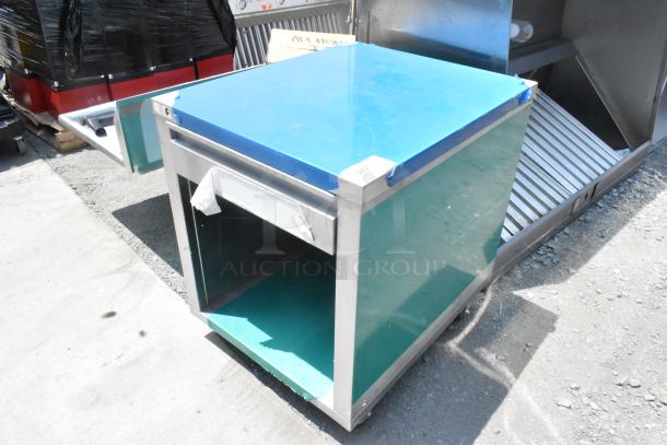 Stainless steel counter with blue covering, featuring a drawer and green under-shelf, in good condition for auction.