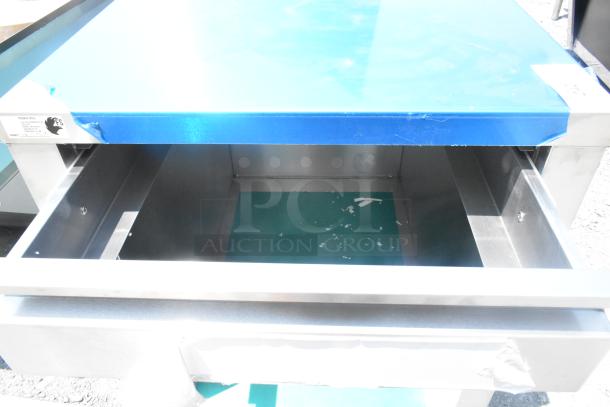 Stainless steel counter with drawer and under shelf. Features blue protective cover, some wear inside. Ideal for kitchens.