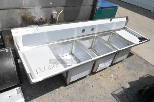 Brand new Regency 600S31620218 stainless steel three-bay sink with dual drain boards, scratch and dent condition, no legs.