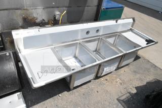 Brand new Regency 600S31620218 stainless steel three-bay sink with dual drain boards, scratch and dent condition, no legs.