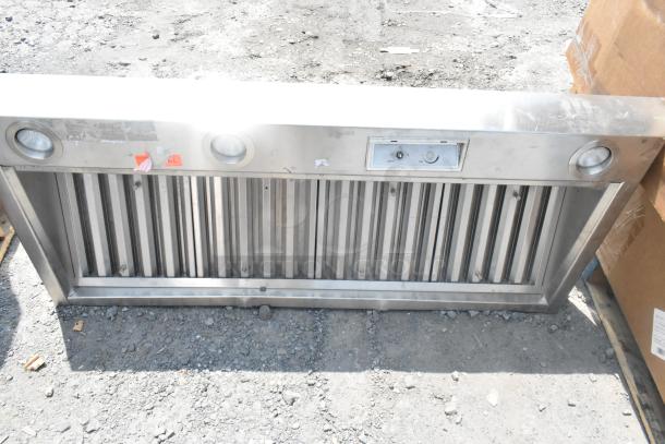 Stainless steel range hood with dual lights and vent controls; appears unused in good condition.