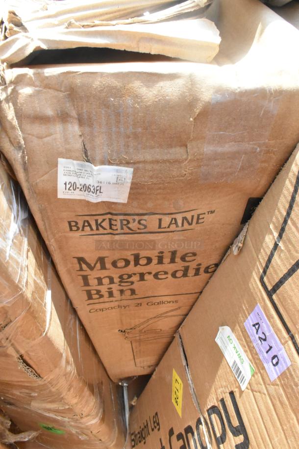 Brown cardboard boxes labeled "Baker's Lane Mobile Ingredient Bin," 21-gallon capacity, and "Straight Leg Canopy," showing wear.