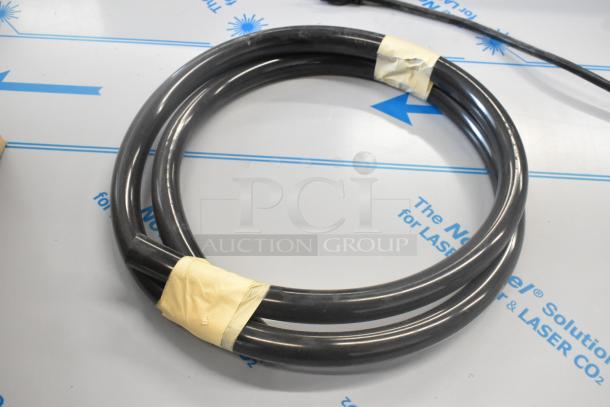 Coiled black hose with yellow tape securing sections, part of a larger auction lot including commercial casters.