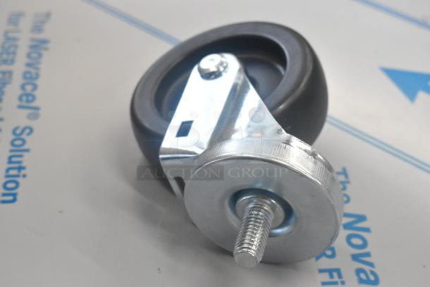 "Commercial caster with metal frame and rubber wheel on white background, part of auction lot with hose."