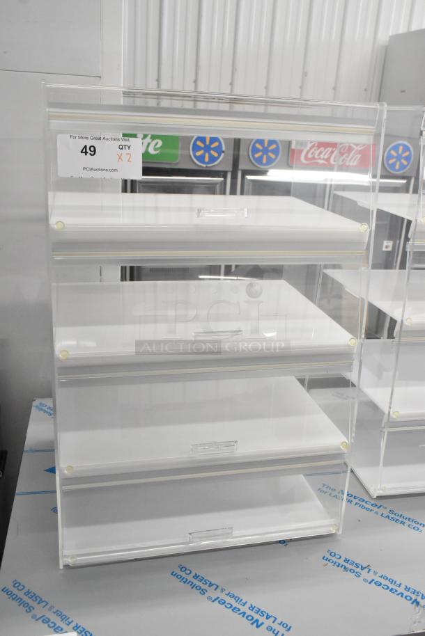 Clear poly countertop dry display case, four shelves, new condition, transparent design, auction label indicating quantity of two.