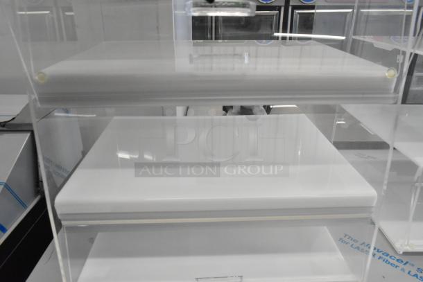 Clear poly countertop dry display case merchandiser, featuring two levels. Ideal for retail, in excellent condition.