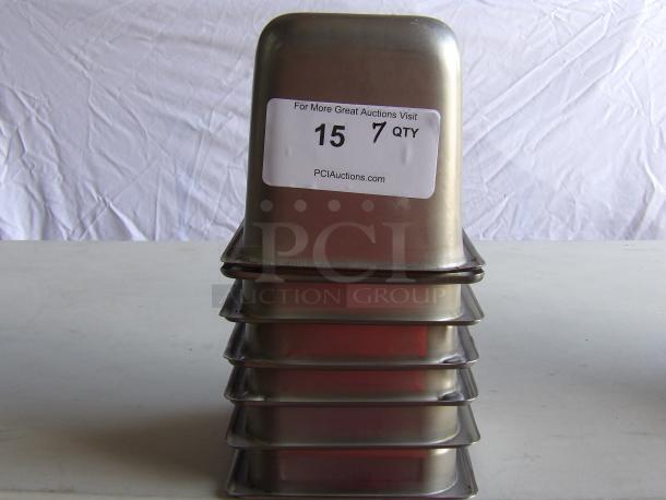 Seven commercial stainless steel steam table pans stacked, labeled with auction details. Durable, ideal for professional kitchens.