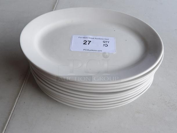 Stack of 10 ivory stoneware platters, 12 1/2" x 8 7/8", wide rim, rolled edge. Label reads: "27 QTY 10, PCIAuctions.com".