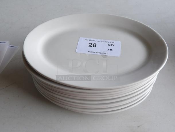 10 ivory stoneware oval platters with wide rims, 12 1/2" x 8 7/8". Features lot tag "28, QTY 10" from PCAuctions.com.