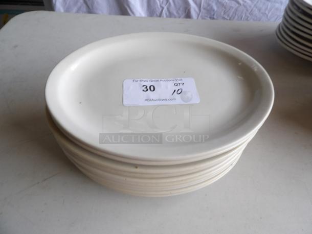 Stack of 10 ivory oval stoneware platters with wide rim, 12.5" x 8.875", rolled edge. Condition appears good.