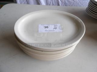 Stack of 10 ivory oval stoneware platters with wide rim, 12.5" x 8.875", rolled edge. Condition appears good.