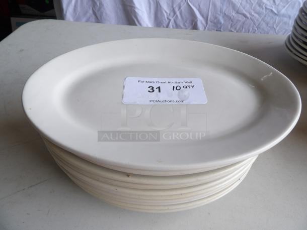 Set of 10 ivory stoneware platters, 12 1/2" x 8 7/8", wide rim, rolled edge. Some signs of use. Auction label reads "31, 10 QTY."