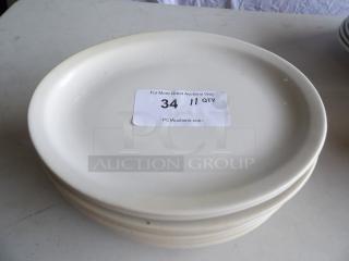 12 1/2" x 8 7/8" Ivory wide rim oval stoneware platters, stacked, with label indicating 11 quantity available.