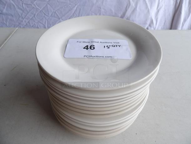 Stack of 15 bright white 7 1/8" stoneware plates with wide rim and rolled edge. Tag indicates "15 QTY."