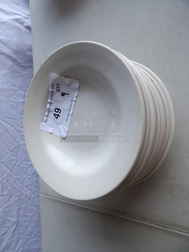 9 bright white stoneware bowls with wide rolled edges for soup and pasta. Each bowl marked with auction tag "Lot 49".