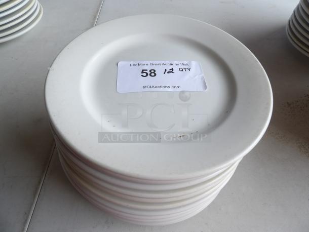 Stack of 12 bright white 9" stoneware plates with wide rims and rolled edges. Label indicates a quantity of 12.