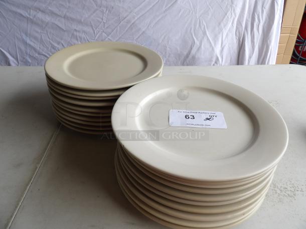 12" round bright white stoneware plates, set of 20. Excellent condition, stack of plates with auction label visible.