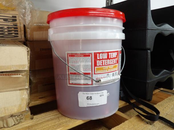 Low Temp Detergent, two-thirds full, in a red-lidded 5-gallon bucket. Label indicates machine detergent use.