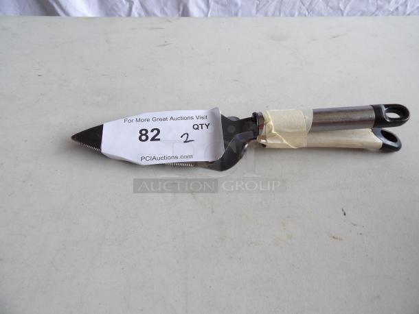 Triangular Pie Carver with steel blade and double handle, in good condition. Auction tag reads "82" and "2" from PCI Auctions.