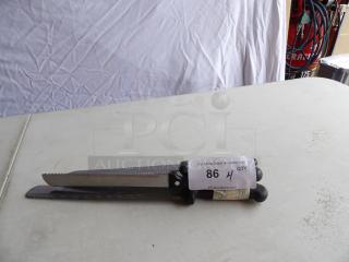Four assorted carving knives with black handles on a table. Some wear visible. Labeled "86 4 QTY" for auction.