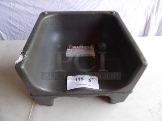 Brown hard plastic booster seat with warning label; auction tag labeled "115, Qty 3." Slight wear visible.