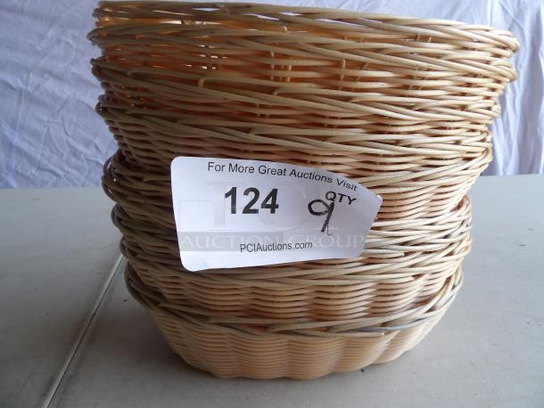 Nine woven bread baskets stacked; natural color, good condition. Label shows auction lot 124, quantity 9.