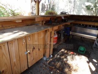 L-shape wood bar on casters, 8' long, 48" wide x 44" tall, features storage and metal sink, suitable for outdoor use.