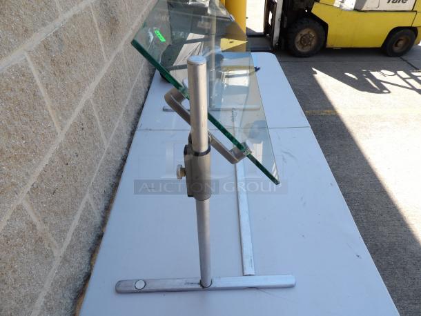 Adjustable height glass food protector with metal frame, used condition. Ideal for buffet or food service environments.