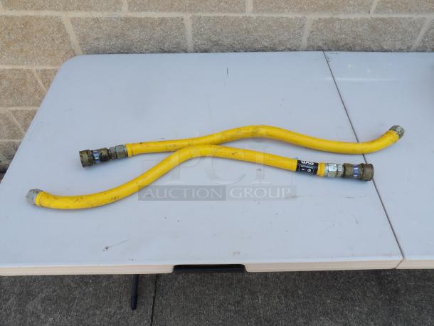 Yellow 3/4" gas line with metal connectors, moderate wear, visible label indicates "GAS" and specifications.