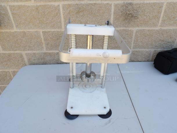 Metal pineapple corer with sturdy frame, springs, and base. Used condition with minor wear. Ideal for commercial use.