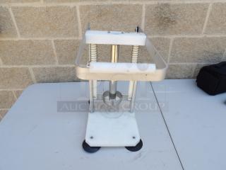 Metal pineapple corer with sturdy frame, springs, and base. Used condition with minor wear. Ideal for commercial use.