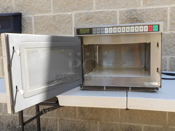 2016 Panasonic NE-12523 stainless steel commercial countertop microwave oven, open door, keypad visible, good condition.