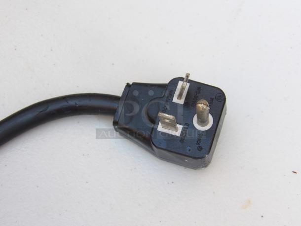Close-up of a black three-prong plug for the Panasonic NE-12523 microwave, showing standard electrical connections.