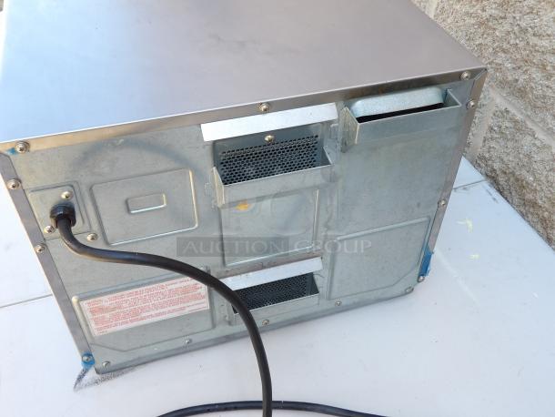 Back view of 2016 Panasonic NE-12523 stainless steel commercial microwave, showing power cord and vents, clean condition.