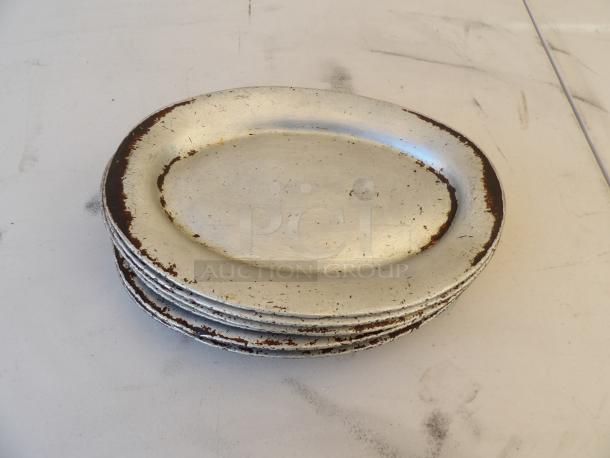 Oval aluminum sizzler platter, 11.5x8 inches, worn condition with visible scratches and discoloration. Suitable for auctions.