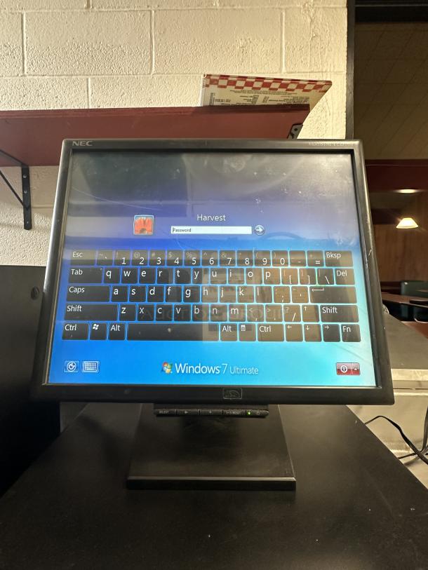 NEC point of sale system with Windows 7, cash drawer, and cables. Features virtual keyboard and login screen display.