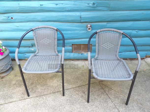 Pair of like-new black metal mesh patio armchairs with curved armrests, featuring durable woven design.