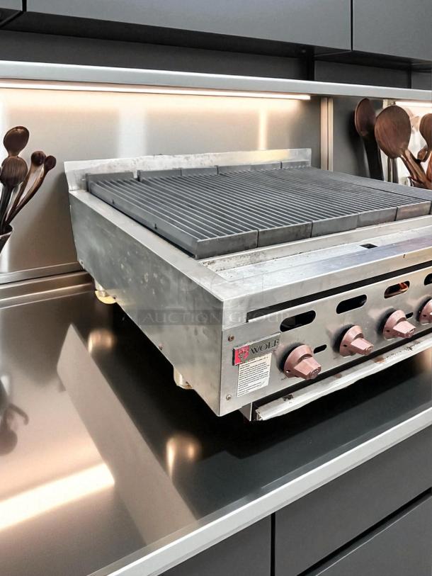 Wolf Range Co. 6-burner commercial gas charbroiler in great condition, natural gas, fully tested, visible controls, branding.