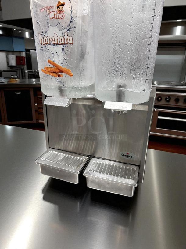 Crathco D25-3 cold beverage dispenser, 5-gallon dual tanks, excellent condition, labeled for horchata, stainless steel base.